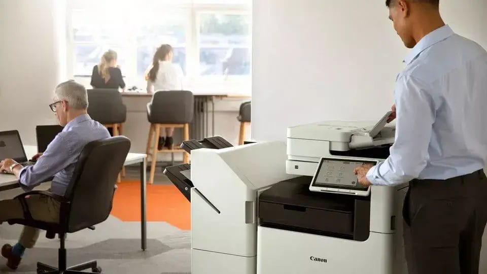 Man using Canon multifunction printer in modern office